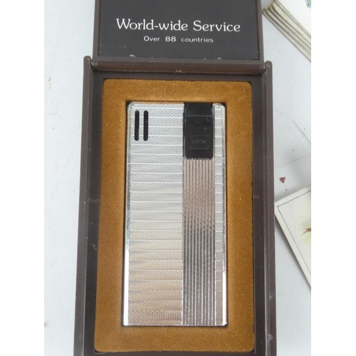 8 - A collection of vintage cigarette cards and a cased Win International cigarette lighter.