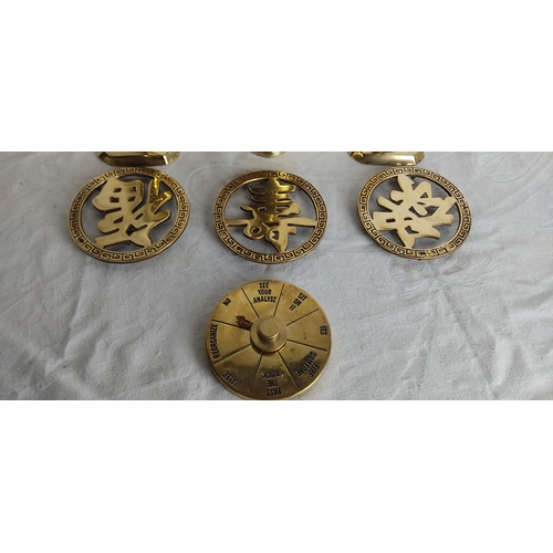 88 - A pair of vintage brass candlesticks, a decorative brass vase, three brass trivets and more.