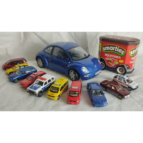 89 - A large Maisto Volkswagen New Beetle, a vintage Smarties sweet tin and other collectors toy cars.