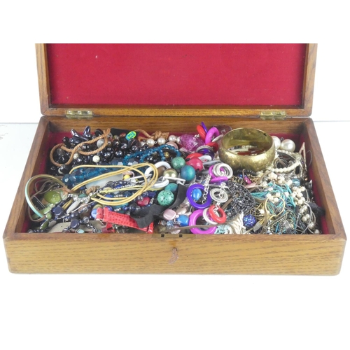 123 - An antique oak canteen of cutlery box and a large lot of assorted costume jewellery.