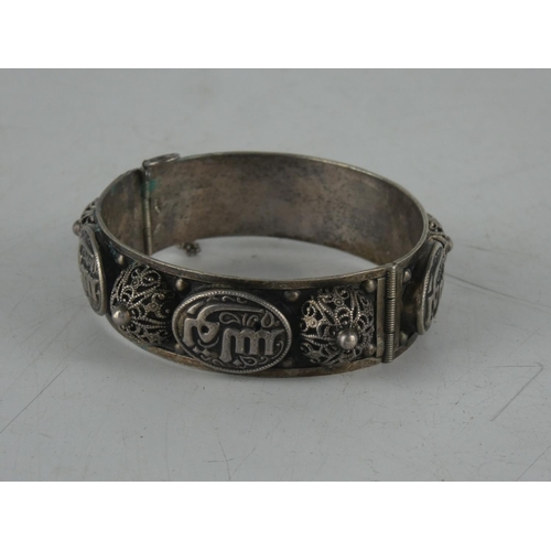 145 - A decorative Moroccan style white metal bangle.