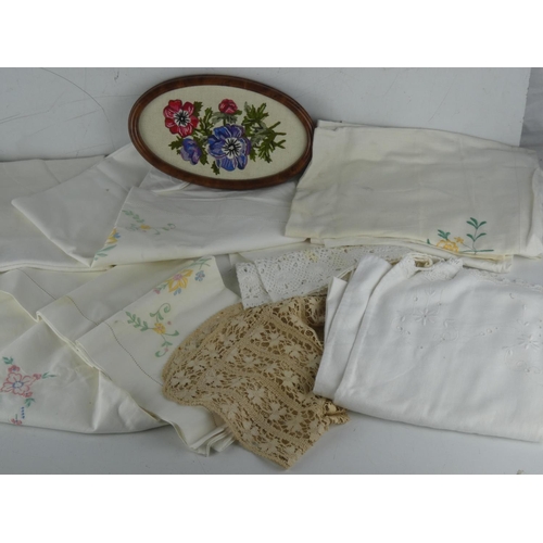 223 - A lot of assorted vintage linen table cloths and a framed tapestry panel.