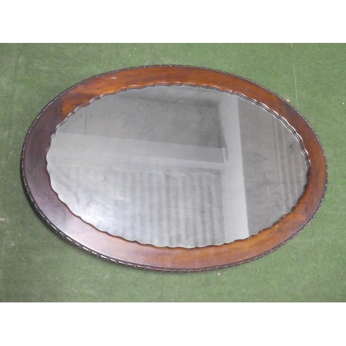 347 - An oval framed mirror.