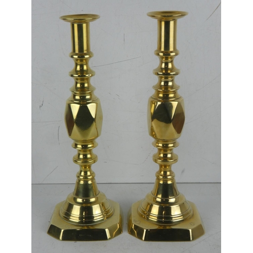 387 - A pair of antique brass 'King of Diamond' pattern candlesticks.