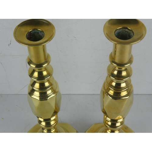 387 - A pair of antique brass 'King of Diamond' pattern candlesticks.