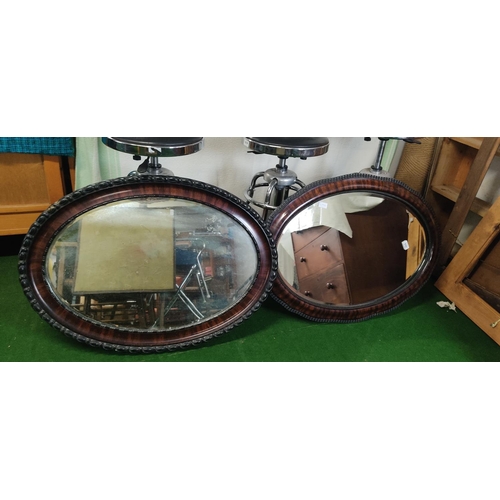 449 - Two large oval framed mirrors.