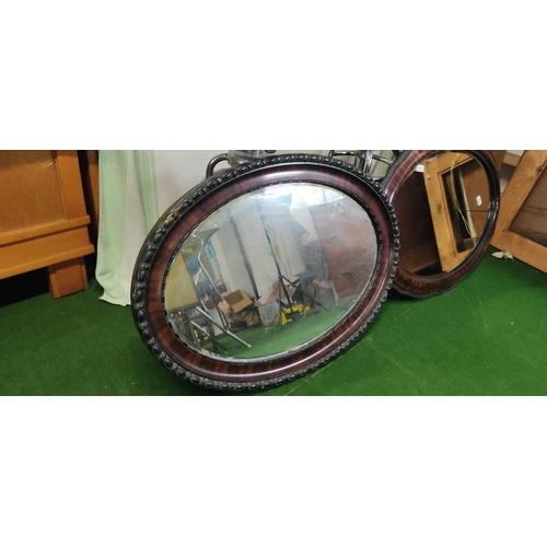 449 - Two large oval framed mirrors.