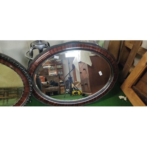 449 - Two large oval framed mirrors.