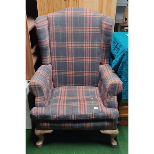 450 - A large wingback armchair with tartan upholstery.