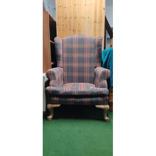 450 - A large wingback armchair with tartan upholstery.