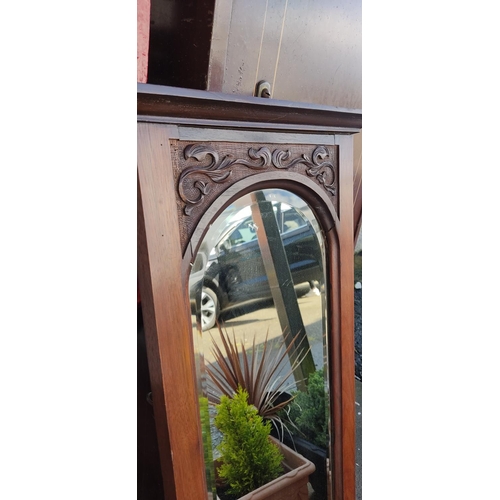 12 - An antique mirror with bevelled glass & carved frame. 39x101cm