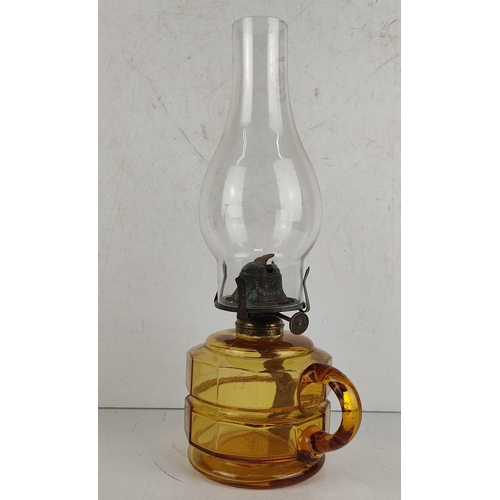 14 - An antique oil lamp with amber glass base.