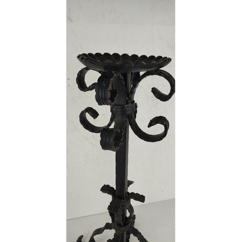 22 - A large decorative wrought iron candlestick. 51cm tall.