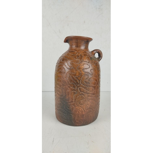 29 - An antique salt glaze jug with nail punch decorative design.