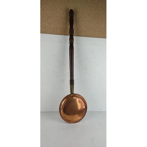 46 - A vintage copper bed pan with mahogany turned handle.