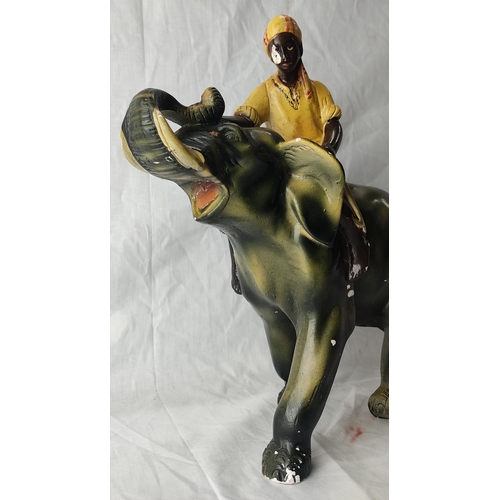 71 - A vintage clay pottery ornament of an elephant and mahout (a/f). 30cm tall.