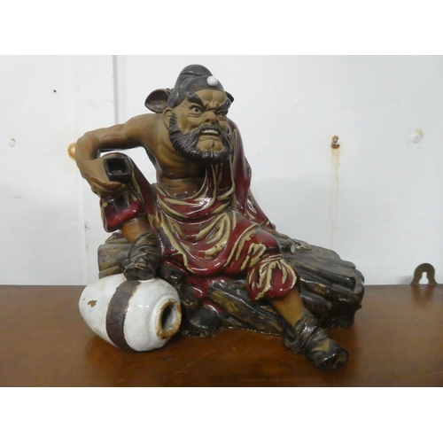 235 - A large Chinese Shiwan glazed figure of Zhong Kui, in seated position holding a cup, with impressed ... 