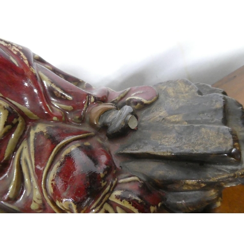 235 - A large Chinese Shiwan glazed figure of Zhong Kui, in seated position holding a cup, with impressed ... 