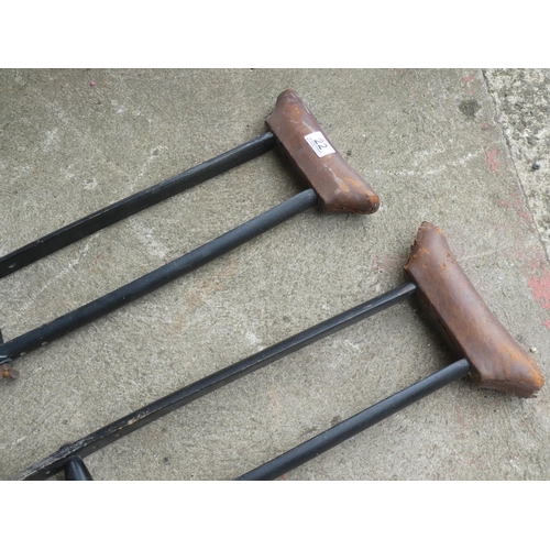 22 - A pair of vintage wooden crutches with leather covered armrests.