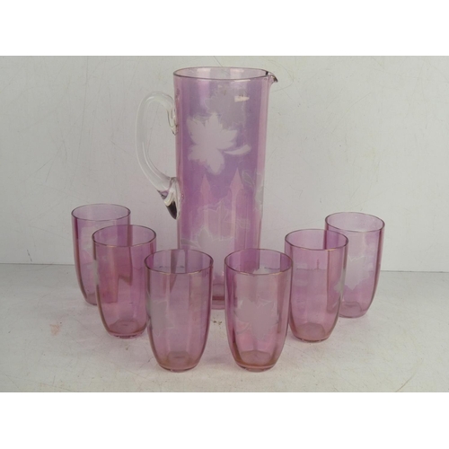 41 - A vintage ruby glass water jug and six glasses set with etched leaf design.