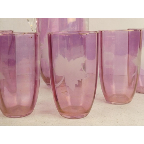 41 - A vintage ruby glass water jug and six glasses set with etched leaf design.