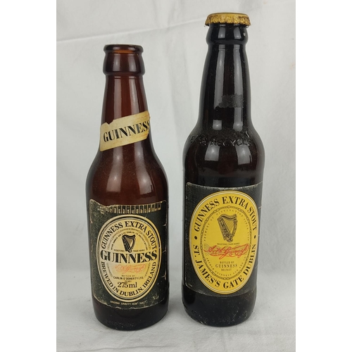 103 - Two vintage Guinness bottles, 22cm and 20cm.