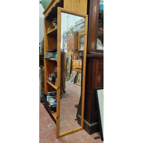 142 - A pine framed wall mirror, 128cm x 34cm.