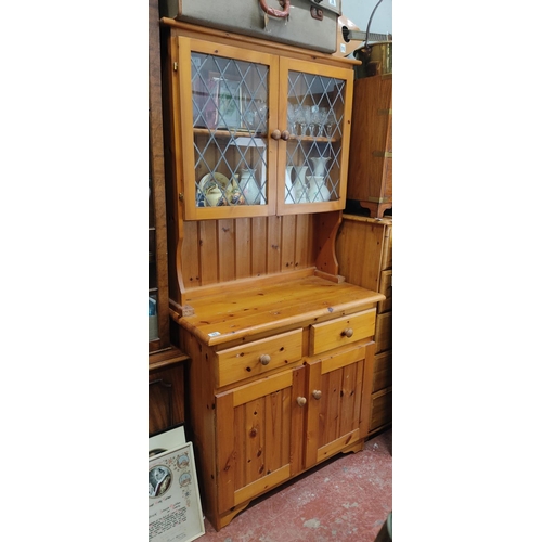 55 - A pine kitchen dresser with lead glass panels.