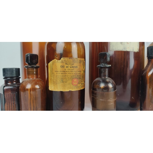76 - A collection of vintage coloured glass chemist bottles, some with original labels.