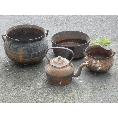 488 - Three antique three legged black pots and an antique kettle (a/f).