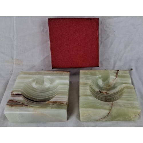 100 - Pair of polished onyx ashtrays featuring natural green and brown striations, with a red box for stor... 