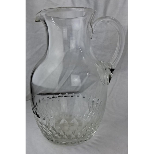 112 - Clear glass pitcher featuring an intricate cut crystal design around the base. It has an elegant han... 