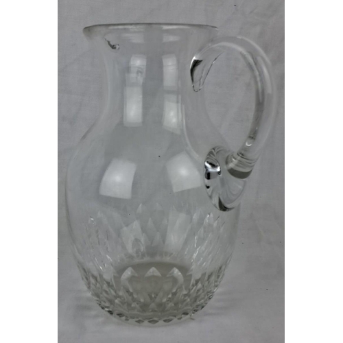 112 - Clear glass pitcher featuring an intricate cut crystal design around the base. It has an elegant han... 