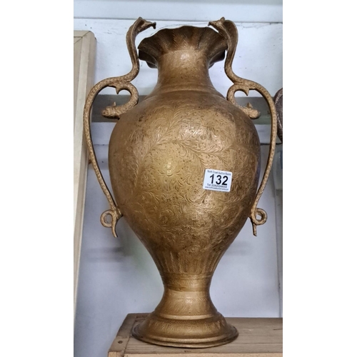 132 - Intricately engraved brass urn with ornate cobra snake handles and flared rim, featuring detailed fl... 