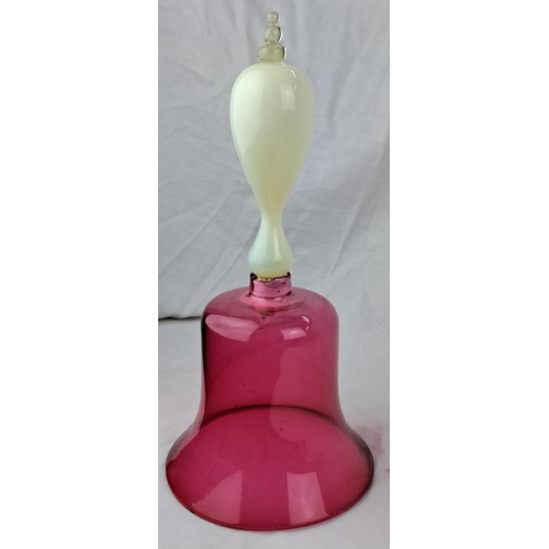 144 - Antique Ruby glass bell with uranium glass handle. Measuring 11