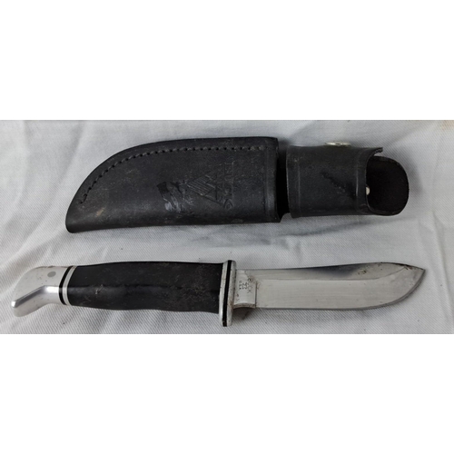 18 - Buck USA fixed-blade knife with black handle and metal guard, accompanied by black leather sheath em... 