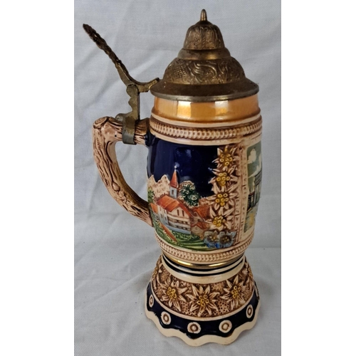 32 - Vintage German beer stein with painted village scenes and floral detailing. Features a lidded top an... 