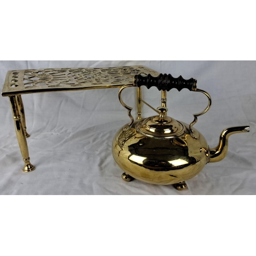 33 - Brass Victorian-style kettle and trivet set, featuring intricate detailing and a black wooden handle... 