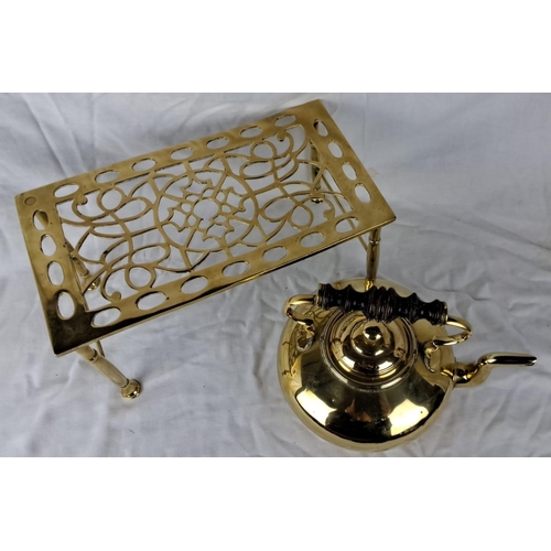 33 - Brass Victorian-style kettle and trivet set, featuring intricate detailing and a black wooden handle... 