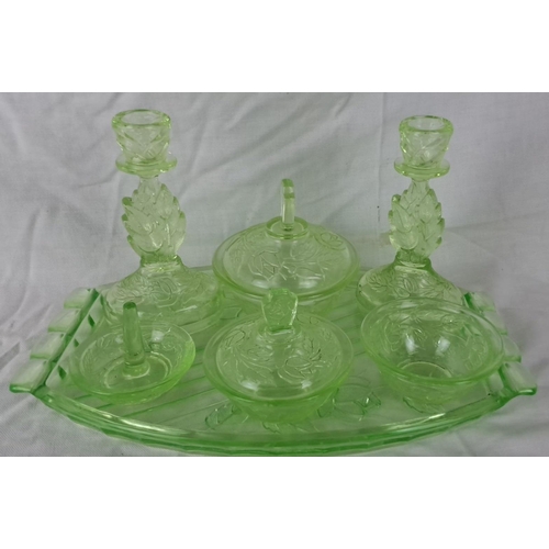 44 - Art Deco uranium glass vanity set with intricate floral engravings. The ensemble includes two candle... 