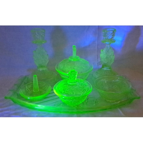 44 - Art Deco uranium glass vanity set with intricate floral engravings. The ensemble includes two candle... 