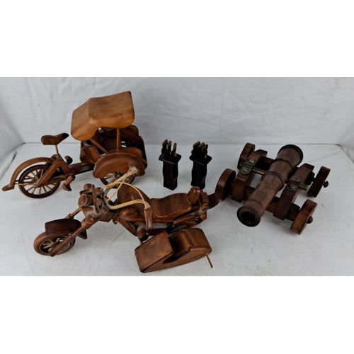 563 - Set of wooden collectibles. Includes a motorcycle, tricycle, and cannon models, with two intricately... 