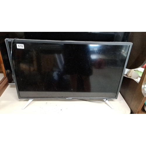 569 - Sharp Aquos television. Features a sleek black frame and modern stand. Measuring 32