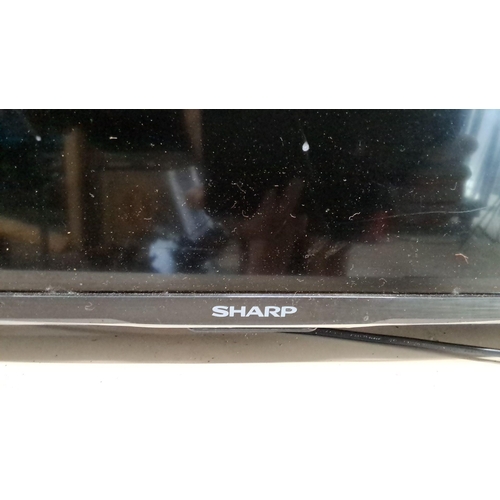 569 - Sharp Aquos television. Features a sleek black frame and modern stand. Measuring 32