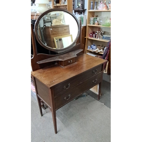 577 - Early 20th-century mahogany dressing table with an oval mirror, two drawers, and a central small dra... 