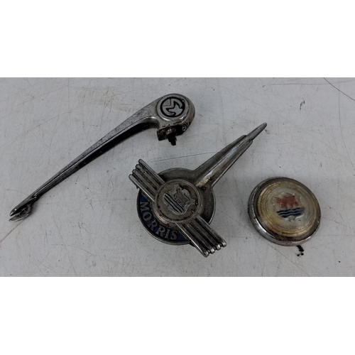 585 - Vintage Morris car badges and parts, including a chrome-plated hood ornament and a hubcap, featuring... 