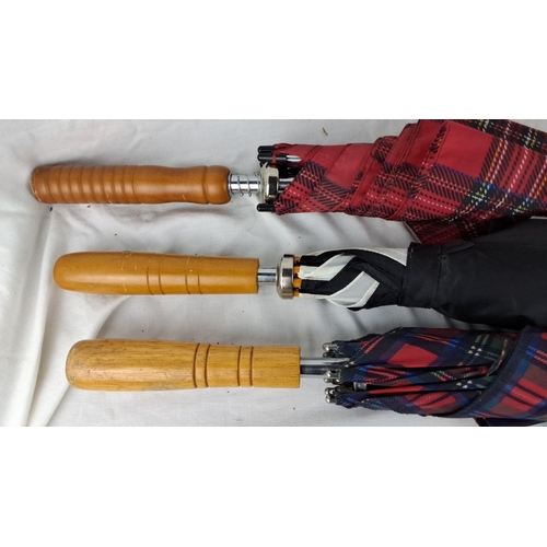 59 - Set of three plaid umbrellas with wooden handles. Two red tartan and one black with multicolor patte... 