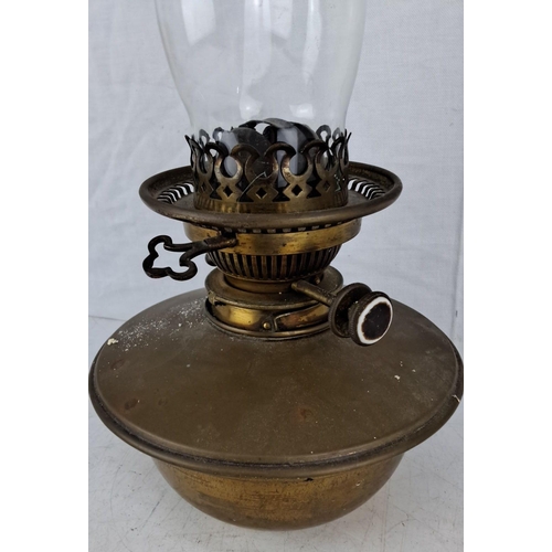 592 - Antique brass oil lamp with ornate burner and clear glass chimney. Marked 