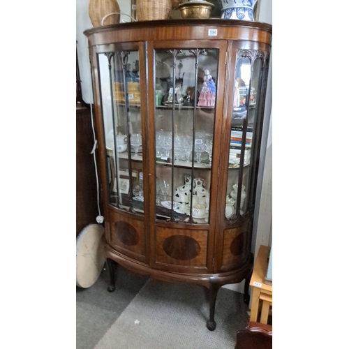 594 - Edwardian mahogany display cabinet, curved glass panels with carved detailing, circa early 1900s.