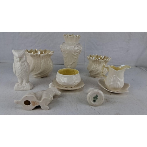 614 - Collection of 8 Belleek pottery items includes owl and dog figurines, a pitcher with a plate, vases,... 